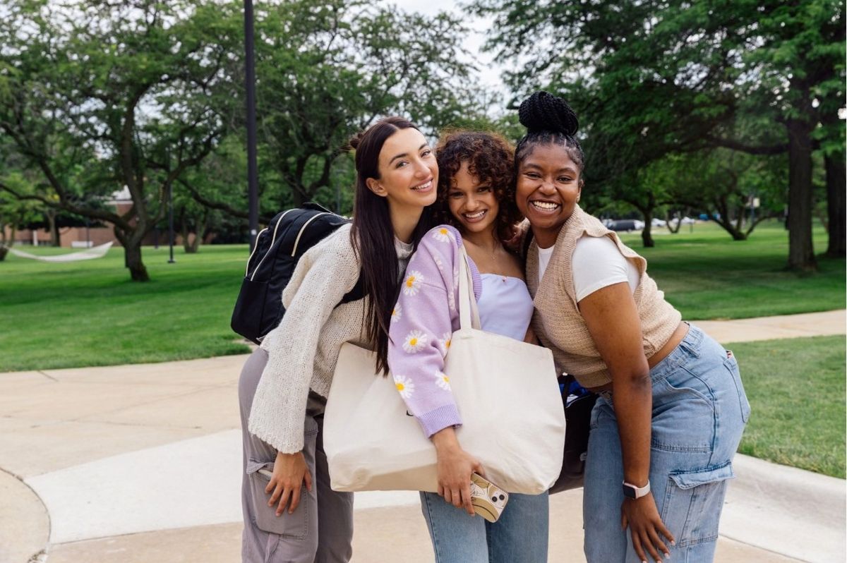 Three students smiling together on campus